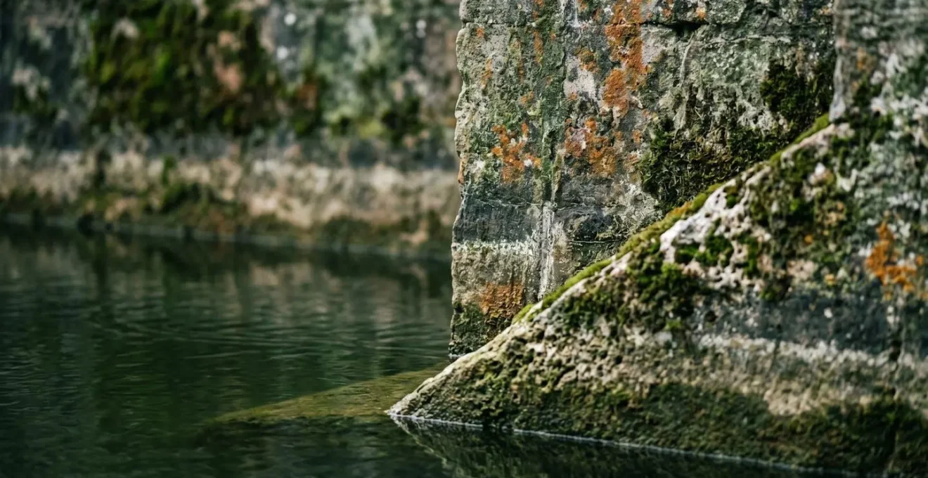 Douves en eau entourant un domaine historique avec système de régulation visible